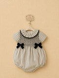Striped smocked baby romper with black velvet bows.
