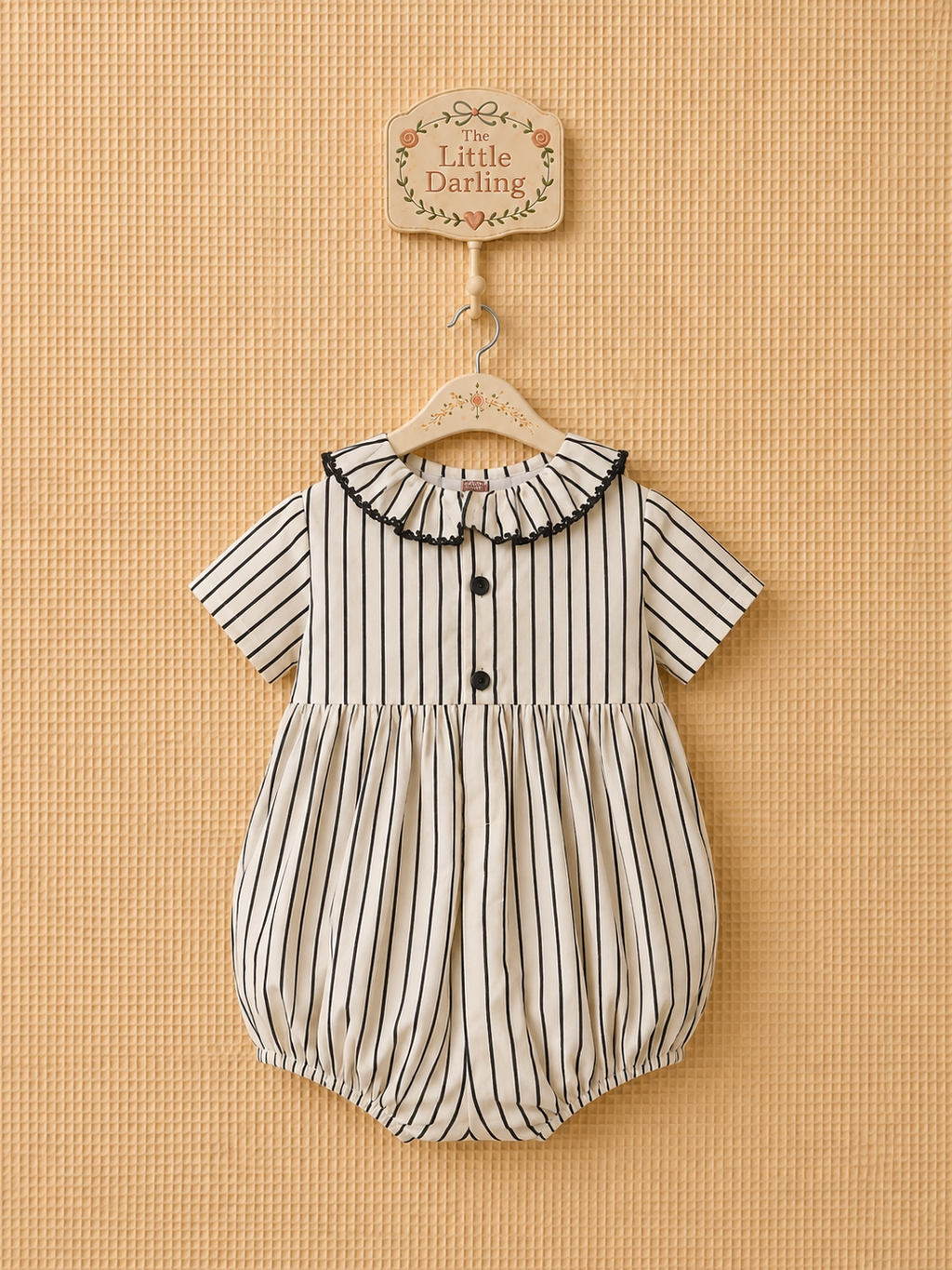 Striped smocked baby romper with black velvet bows.