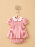 Pink smocked dress with an embroidered white collar, matching bloomers.